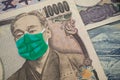 Men wear face mask on Japanese yen bill banknote background. Global novel coronavirus Covid-19 outbreak effect to Japan