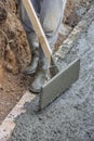 Men wearing rubber boots submerged in poured concrete