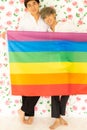 Men were happy together over rose background holding rainbow flag .  LGBT gay couple love concept Royalty Free Stock Photo