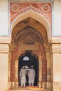 Men in white dresses standing at Isa Khan Niyazi tomb entrance,