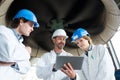 men and woman engineers using tablets for monitoring factory