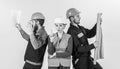 Men and woman in helmets carefree with hammer and project,