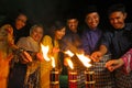 Men and woman light up the Malay tradition oil lamp or pelita