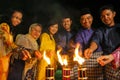 Men and woman light up the Malay tradition oil lamp or pelita