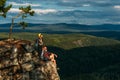 A man and a woman with backpacks on the mountain admire the panoramic view. A couple in love on a rock admires the beautiful views Royalty Free Stock Photo