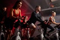 Men and women biking in gym, exercising legs doing cardio workout cycling bikes Royalty Free Stock Photo