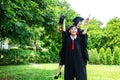 A man and woman couple dressed in black graduation gown or graduates with congratulations with graduation hats is standing Royalty Free Stock Photo