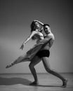A man and a woman are dancing modern ballet. Acrobatic couple perform number on a white background. A duet of gymnasts