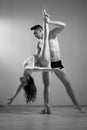A man and a woman are dancing modern ballet. Acrobatic couple perform number on a white background. A duet of gymnasts