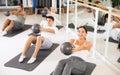 Men and women doing pilates exercises with fitness ball at gym Royalty Free Stock Photo