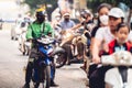 Men and women driving motorbikes and mopeds in a heavy city traffic in Hanoi, Vietnam Royalty Free Stock Photo