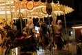 Enchanting Nighttime Carousel Ride: Joyful Men and Women Revelling in Fairground Delight.