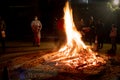 Men women families standing around giant blazing wood fire on lohri holi festival in india Royalty Free Stock Photo