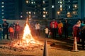 Men women families standing around giant blazing wood fire on lohri holi festival in india Royalty Free Stock Photo