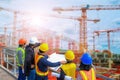 Men and woman meeting with Engineers and supervisors are standing reading the blueprints the construction site