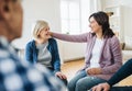 Men and women sitting in a circle during group therapy, supporting each other. Royalty Free Stock Photo