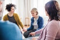 Men and women sitting in a circle during group therapy, supporting each other. Royalty Free Stock Photo