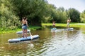 Men and women stand up paddleboarding