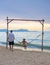 Men and women watching sunset from a hammock on the beach in Pattaya Thailand Ban Amphur beach Royalty Free Stock Photo