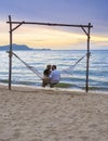 Men and women watching sunset from a hammock on the beach in Pattaya Thailand Ban Amphur beach Royalty Free Stock Photo