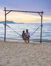 Men and women watching sunset from a hammock on the beach in Pattaya Thailand Ban Amphur beach Royalty Free Stock Photo