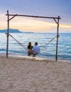 Men and women watching sunset from a hammock on the beach in Pattaya Thailand Ban Amphur beach Royalty Free Stock Photo