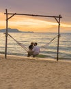 Men and women watching sunset from a hammock on the beach in Pattaya Thailand Ban Amphur beach Royalty Free Stock Photo