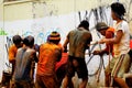 Men work in a team to pull underground cable.