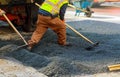 Men at work, urban road under construction, asphalting in progress