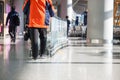 Worker roll a stack of baggage trolleys in the departure area of Airport .