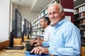 Men working on computers in library Royalty Free Stock Photo