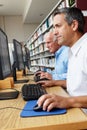 Men working on computers in library Royalty Free Stock Photo