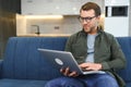 Men working on laptop computer in his room. Home work or study, freelance concept. Young man sitting relaxed on sofa Royalty Free Stock Photo