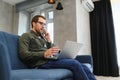 Men working on laptop computer in his room. Home work or study, freelance concept. Young man sitting relaxed on sofa Royalty Free Stock Photo