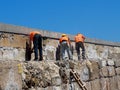 Men Working On Venetian Harbour Wall Heraklion Greece