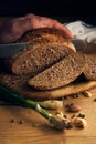 men's hands cut bread with a knife