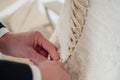 Men& x27;s hands lace up corset on the bride& x27;s dress, close up Royalty Free Stock Photo