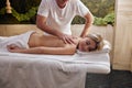 Men& x27;s hands make therapeutic spine back massage for female lying on a massage couch Royalty Free Stock Photo