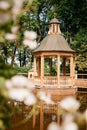 'Menagerie Pond' and Gazebo, Bosquet in The Summer Garden. In the foreground, on the right, blurry leaves of a flowers.