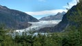 Mendenhall Glacier in Juneau Alaska. Large Glacier sliding into a lake with a waterfall beside it. Very popular tourist stop