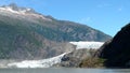 Mendenhall Glacier in Juneau Alaska. Large Glacier sliding into a lake with a waterfall beside it. Very popular tourist stop