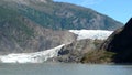 Mendenhall Glacier in Juneau Alaska. Large Glacier sliding into a lake with a waterfall beside it. Very popular tourist stop