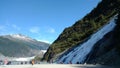 Mendenhall Glacier in Juneau Alaska. Large Glacier sliding into a lake with a waterfall beside it. Very popular tourist stop