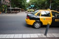 Black and yellow city taxi at intersection of 9 de Julio street and walking street