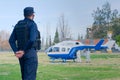 2020-09-06, Mendoza, Argentina - A police officer keeps distance from an emergency services helicopter, carrying an injured person