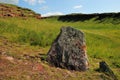 Menhir, tombstone of an ancient burial place near the slope of a high mountain in the summer steppe