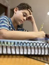 Nine-year-old boy doing his homework in the dining room at home, concentrating Royalty Free Stock Photo