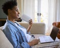 Menopausal Mature Woman At Home With Laptop Having Hot Flush Fanning Herself