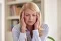 Menopausal Mature Woman At Home Suffering With Headache Pain