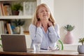 Menopausal Mature Woman Suffering Neck Pain Working On Laptop At Home